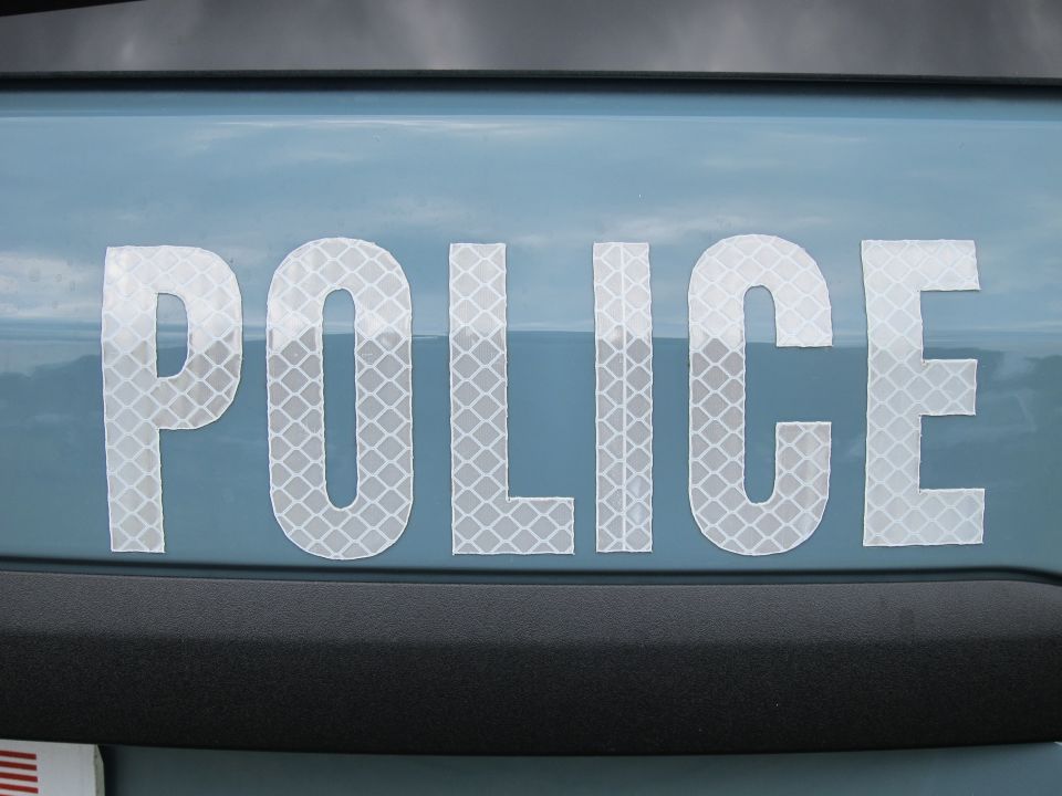 Reflective white POLICE lettering on a light-blue vehicle body panel