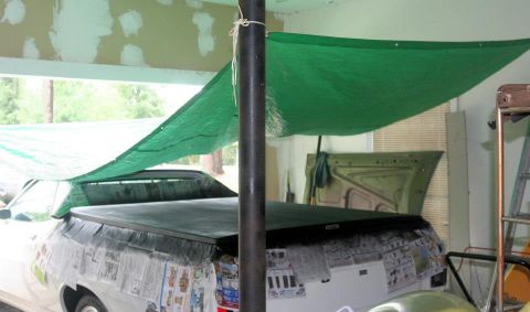 1976 Ford Ranchero - A 1976 Ford Ranchero is seen from the rear, its bed covered and sides taped with newspaper.