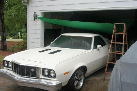 1976 Ford Ranchero - This 1976 Ford Ranchero is parked in a garage, a distinctive grille and hood scoops.