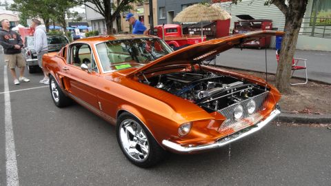 1964 Ford Fairlane - Custom orange coupe with engine exposed, parked on street with people nearby.