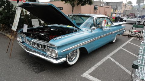 1964 Ford Fairlane - A light blue classic car with its hood up is displayed, with another vehicle seen in the background.