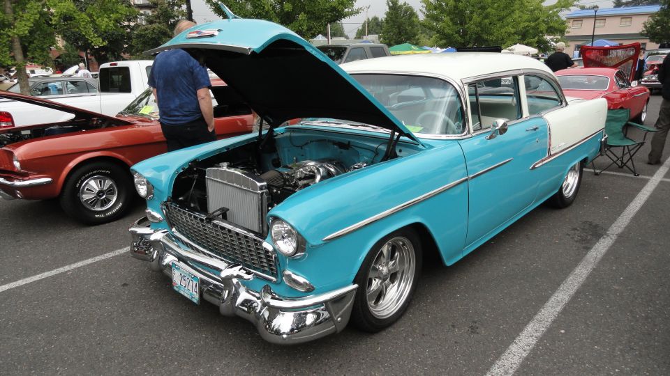 Blue and white 1955 Chevrolet Bel Air with hood open, showing engine