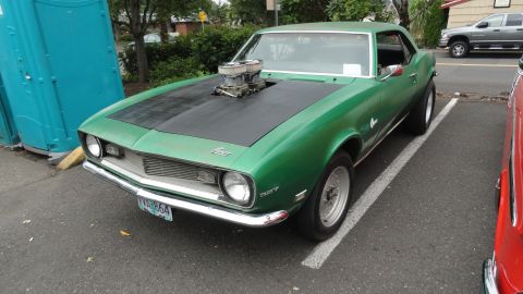 1964 Ford Fairlane - This modified 1967 Chevrolet Camaro features a prominent dual carburetor setup protruding from its hood.