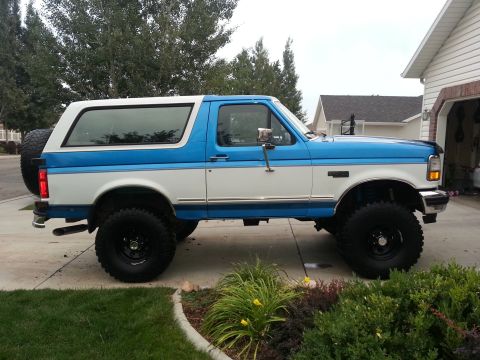 1994 Ford Bronco - This lifted 1994 Ford Bronco is parked in a suburban driveway next to a house.