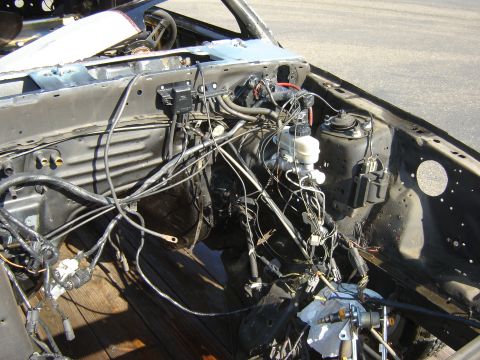 1987 Ford Mustang - The engine bay of a 1987 Ford Mustang shows extensive wiring and disassembled components.