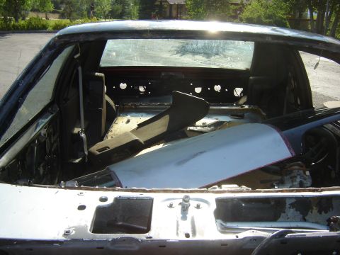 1987 Ford Mustang - The interior of a car has been stripped down, with various parts stored in the rear cargo area.