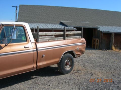 1979 Ford F-150 - A brown 1979 Ford F-150 pickup truck with wooden bed rails is parked in front of a building.