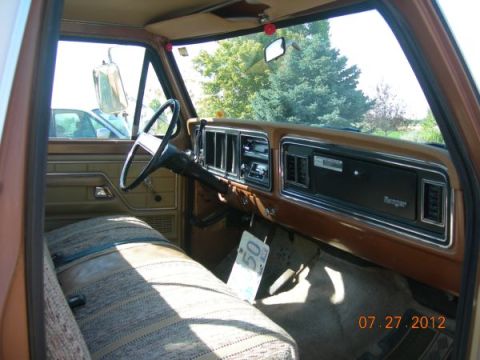1979 Ford F-150 - The interior of a 1979 Ford F-150 shows a brown dashboard and patterned bench seat.