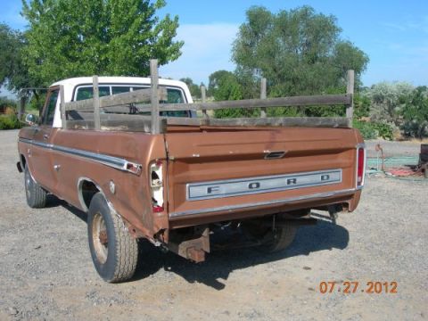 1979 Ford F-150 - This Ford pickup truck features a wooden bed extension and a visible "FORD" tailgate emblem. The year is likely 1977.
