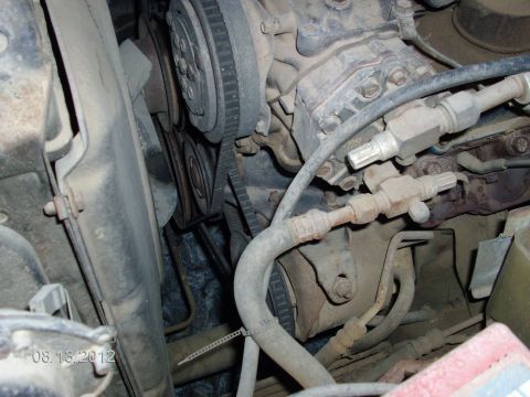 1979 Ford F-150 - The image shows a close-up view of engine components, including a fan belt and various hoses.