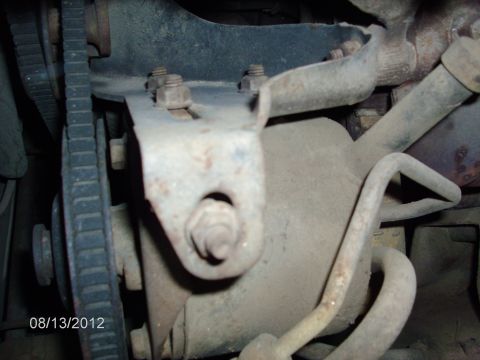 1979 Ford F-150 - Close-up view of a worn engine belt and mounting bracket, showing signs of rust and age.