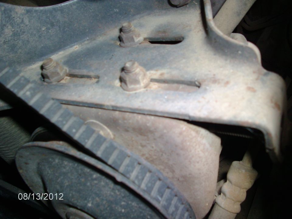 Close-up of engine belt and mounting bracket with nuts and bolts