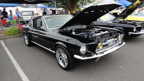1964 Ford Fairlane - A black 1967 Ford Mustang Fastback is displayed with its hood open at an outdoor car show.