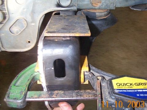 1986 Ford Bronco - A Quick-Grip bar clamp is used to hold a metal bracket in place during a vehicle frame modification.