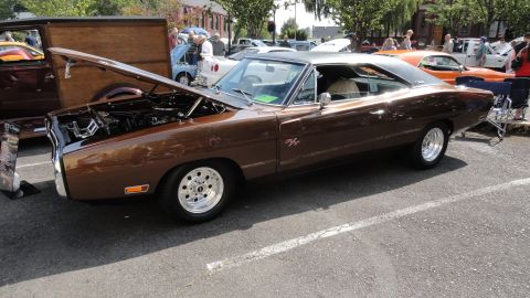 1964 Ford Fairlane - A brown 1969 Dodge Charger is parked with its hood up at an outdoor car show.