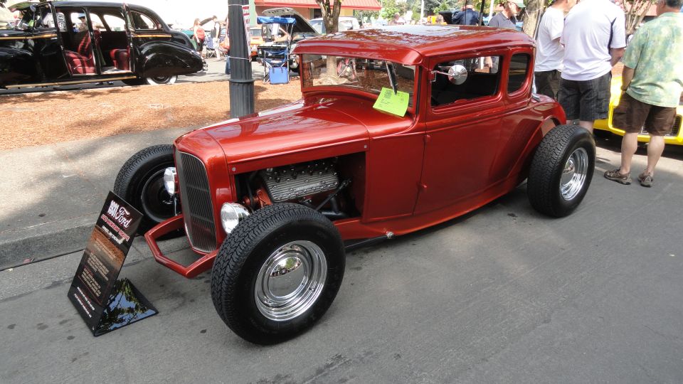 Red hot rod coupe with exposed engine and chrome wheels