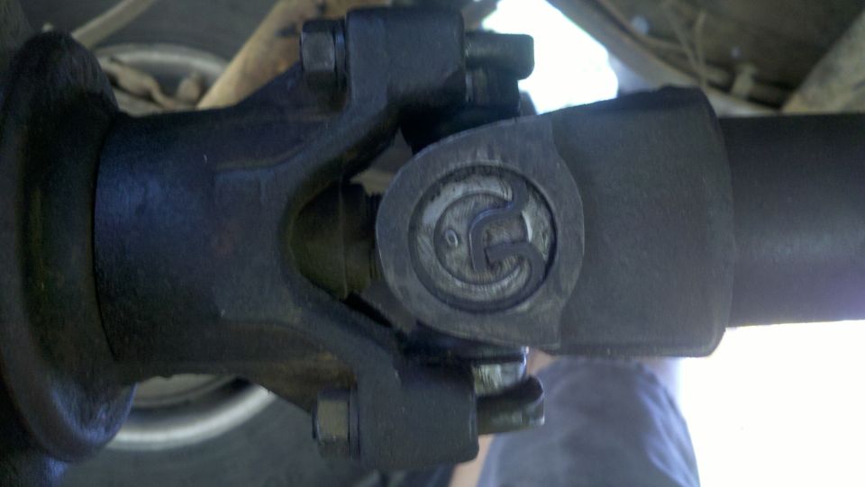 Close-up of a driveshaft u-joint with a circular logo on it