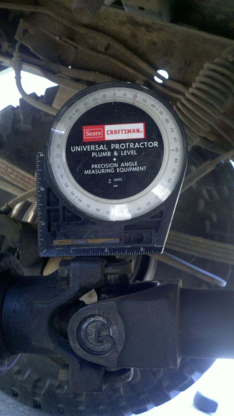 Universal protractor measuring angle on vehicle driveshaft