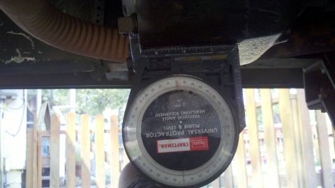 1978 Ford Bronco - A Sears Craftsman universal protractor is used to measure an angle on the underside of a vehicle.