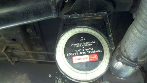 1978 Ford Bronco - Using a Sears Craftsman protractor to measure angle on vehicle undercarriage components.