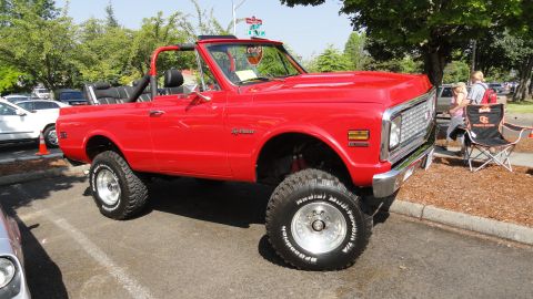1964 Ford Fairlane - This red convertible SUV has a lifted suspension and large off-road tires, suggesting it's built for more than just pavement.