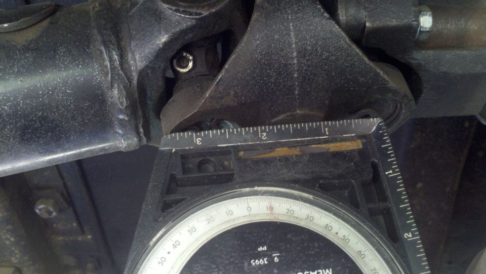 Driveshaft angle gauge measuring a black metal component