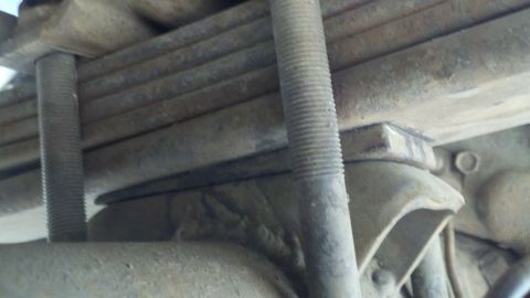 1978 Ford Bronco - Close-up view of a vehicle's rear suspension components, including leaf springs and U-bolts.