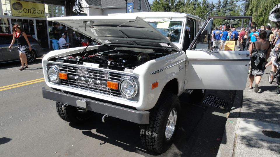 White Ford Bronco, front view, hood and door open. Visible 'FORD' grille