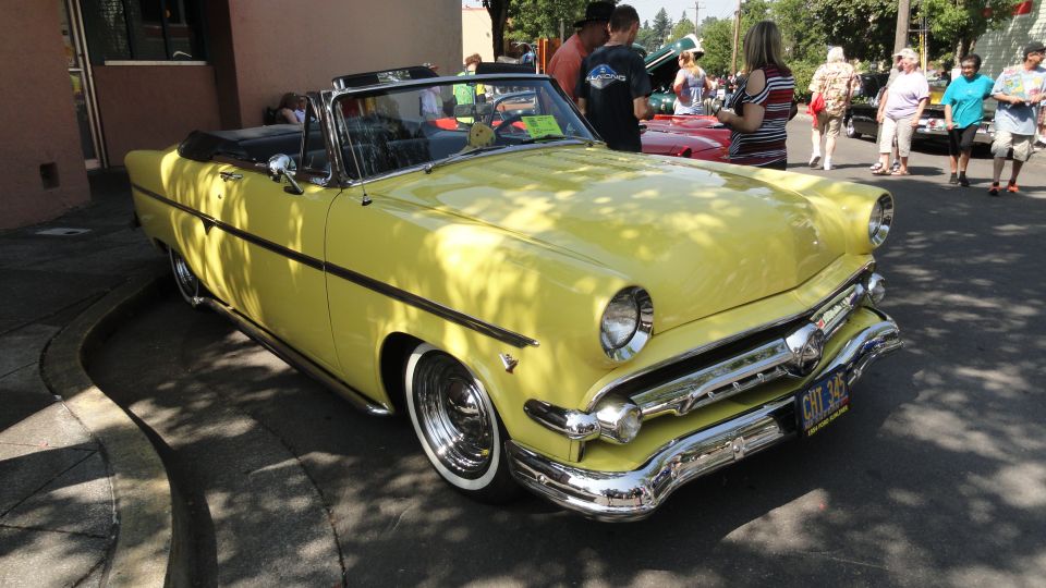 Yellow 1954 convertible with chrome grille and whitewall tires
