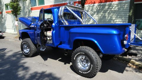 1964 Ford Fairlane - Custom blue pickup truck parked on a street, showing off its lifted suspension and open hood.