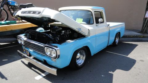 1964 Ford Fairlane - This classic Ford pickup has its hood open, revealing the engine bay. A motorcycle is visible in the background.