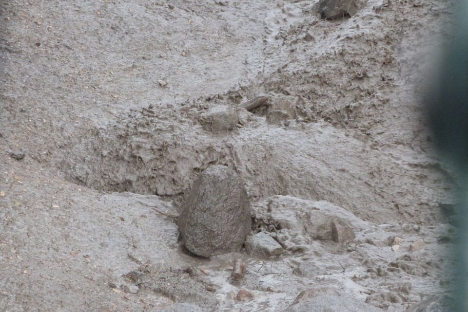 Muddy terrain with rocks and a watermark