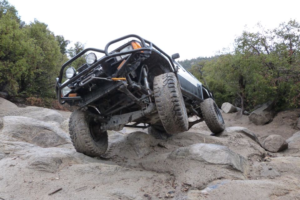 1985 Toyota 4Runner climbing over large rocks on a trail