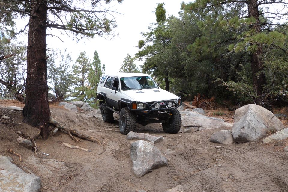 White 1985 Toyota 4Runner navigating rocky terrain