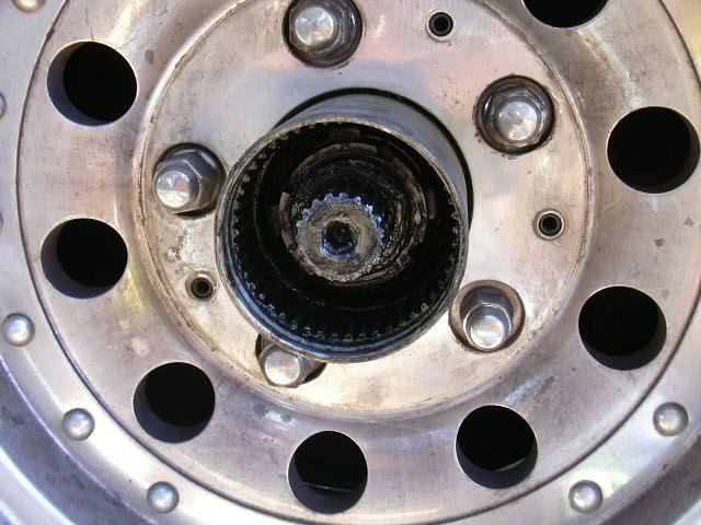 Close-up of an exposed splined axle stub and hub gear inside a steel wheel center