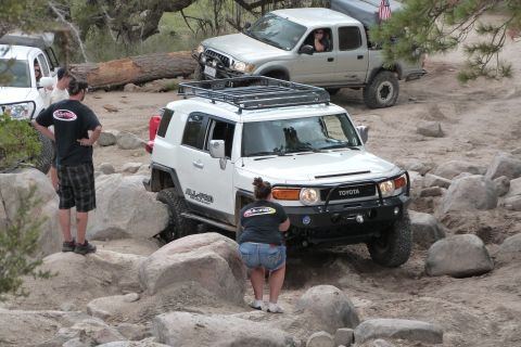 1985 Toyota 4Runner - Two Toyota SUVs tackle a rocky trail, one with a roof rack and the other a pickup truck.