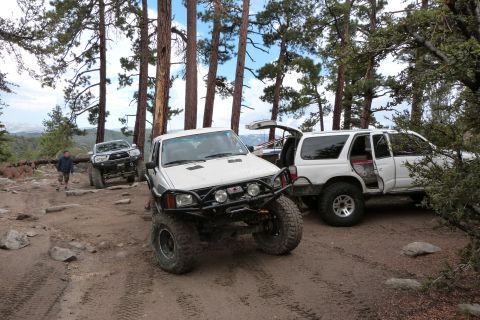 1985 Toyota 4Runner - A white 1985 Toyota 4Runner is parked off-road with other vehicles.