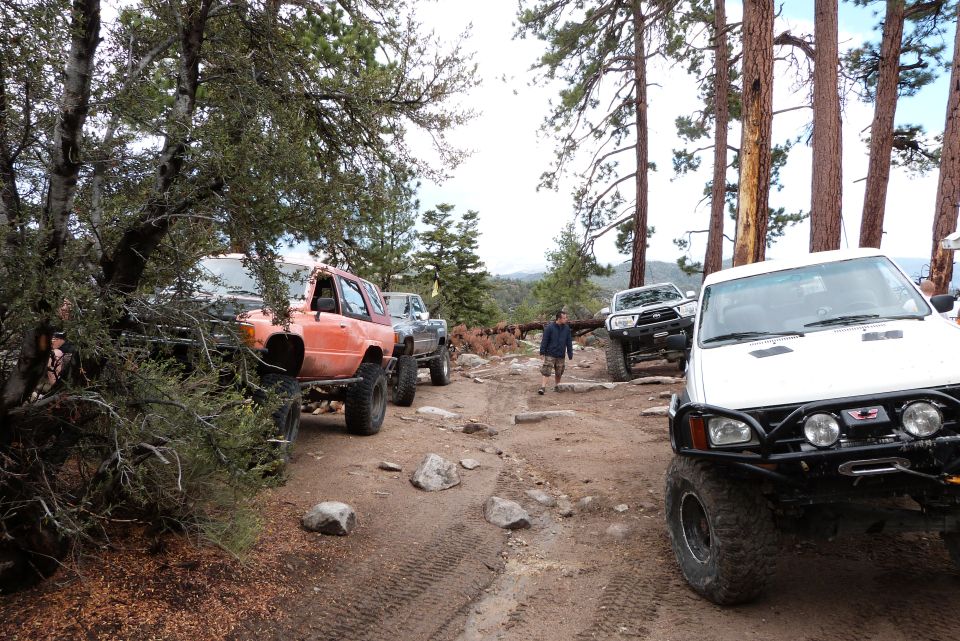 1985 Toyota 4Runner and other off-road vehicles on a dirt trail in a wooded area