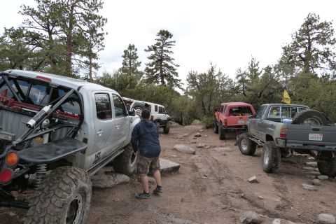 1985 Toyota 4Runner - A group of off-road vehicles navigates a rocky trail in a wooded area.