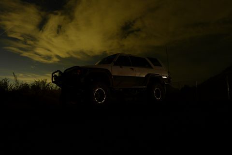1985 Toyota 4Runner - A 1985 Toyota 4Runner is seen at night under a dramatic sky, equipped with a bull bar and two-tone paint.