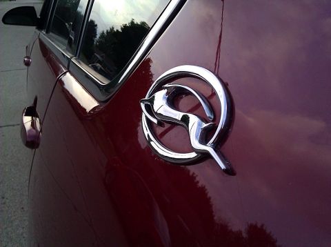 2008 Chevrolet Impala - Close-up of the iconic Impala emblem on the side of a red 2008 Chevrolet Impala.