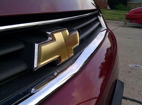 2008 Chevrolet Impala - Close-up of the front grille and gold Chevrolet emblem on a maroon 2008 Impala.