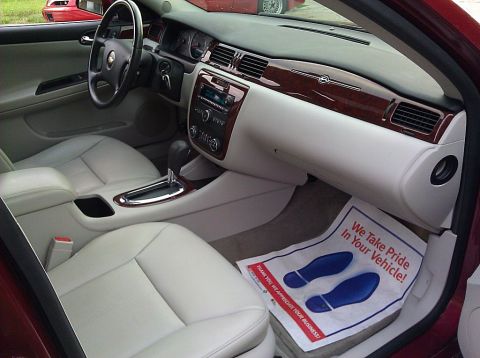 2008 Chevrolet Impala - Interior view of a 2008 Chevrolet Impala, showing light leather seats, wood trim accents, and the dashboard.