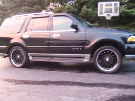 1996 Ford Bronco - This SUV has a side profile view, showing its custom wheels and roof rack.