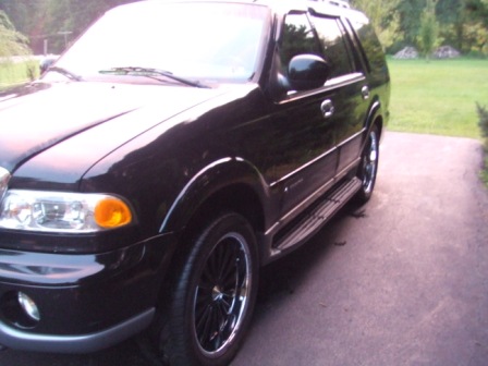 1996 Ford Bronco - This black SUV features chrome trim and custom wheels, seen from a three-quarter front view.