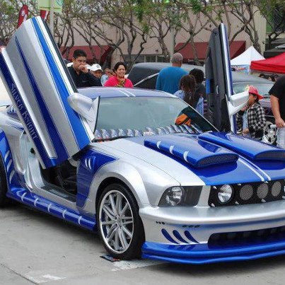 2007 Ford Mustang - This customized 2007 Ford Mustang features striking silver and blue paint, lambo doors, and aggressive hood scoops.