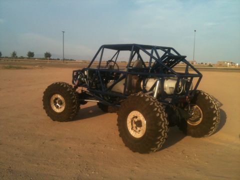 1966 Ford Bronco - Custom blue off-road buggy with large tires and roll cage is parked on dirt.