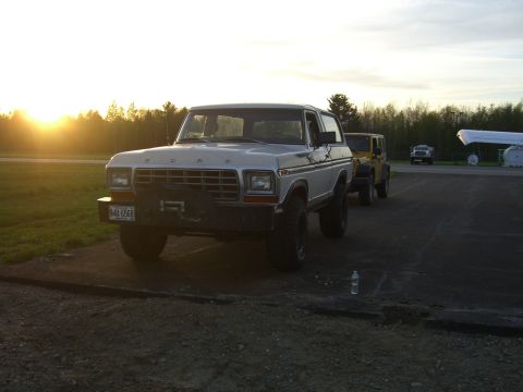 1979 Ford Bronco - A white 1979 Ford Bronco is parked in front of a yellow Jeep at sunset.