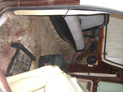 1979 Ford Bronco - The rear interior of a vehicle shows significant wear on the flooring and seats, suggesting a need for restoration.