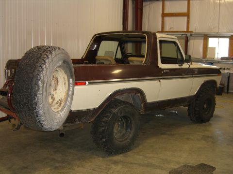 1979 Ford Bronco - This two-tone brown and white 1979 Ford Bronco features a rear-mounted spare tire and a classic body style.